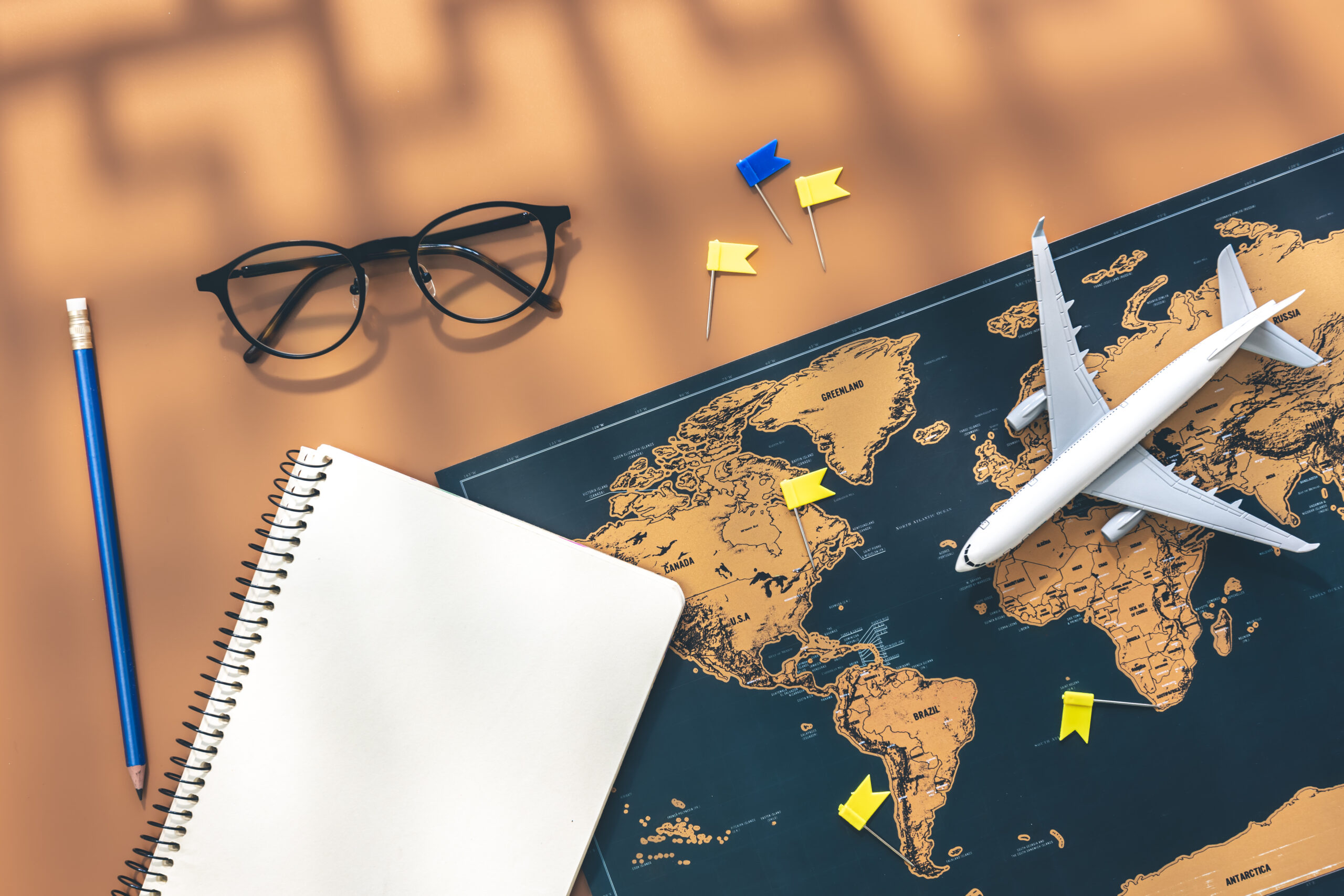 Study abroad roadmap 2027 with world map, airplane and notebook